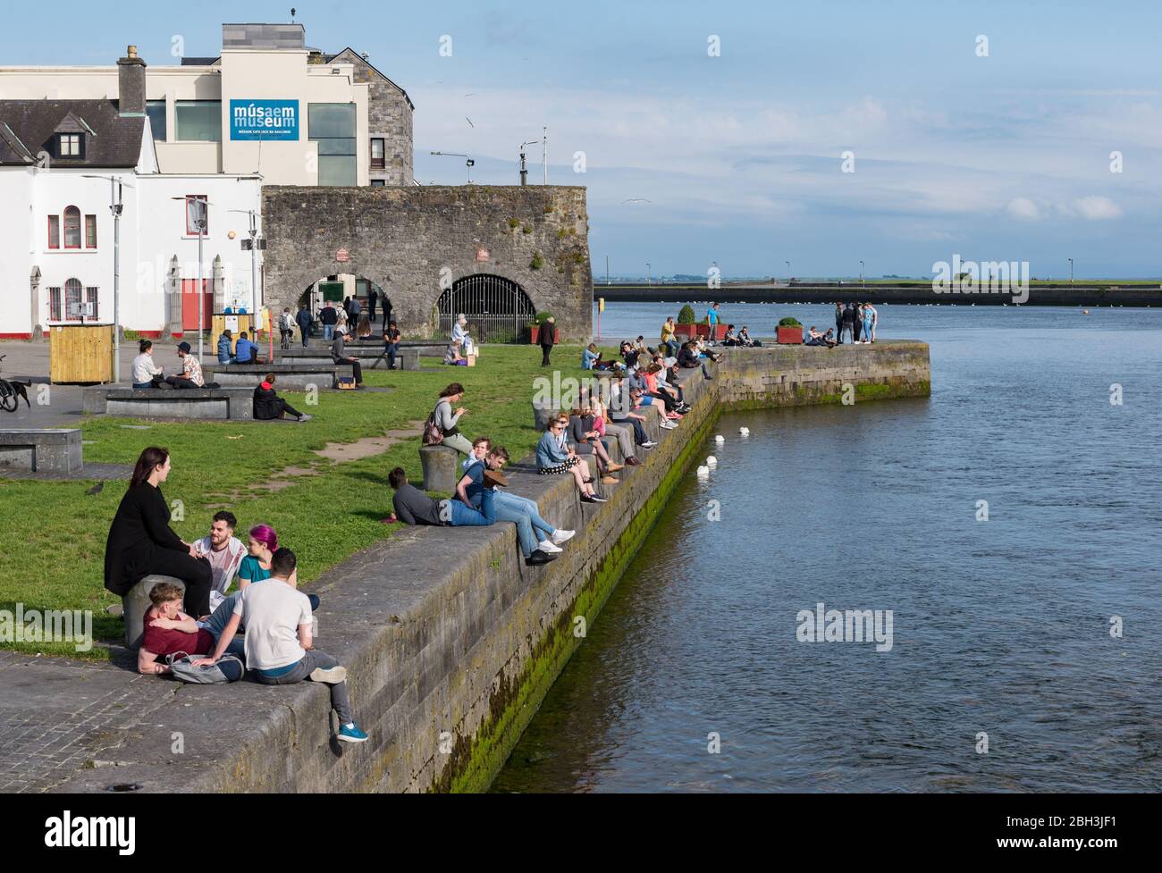 GALWAY, IRELAND JUNE 21, 2017 People socialising and enjoying the view from Spanish Arch