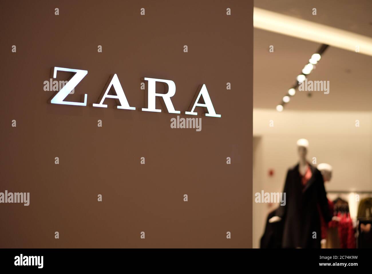 close-up-illuminated-zara-logo-on-the-wall-blur-clothing-store-inside