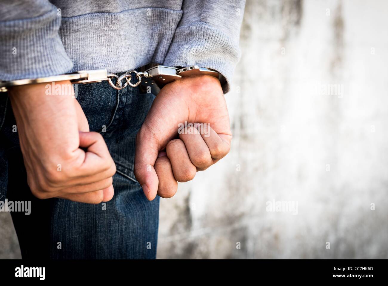 Close up hands tied up handcuffs in behind his body. Arrested man